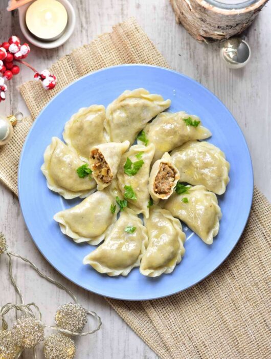 Sauerkraut and mushroom pierogi on a blue plate.