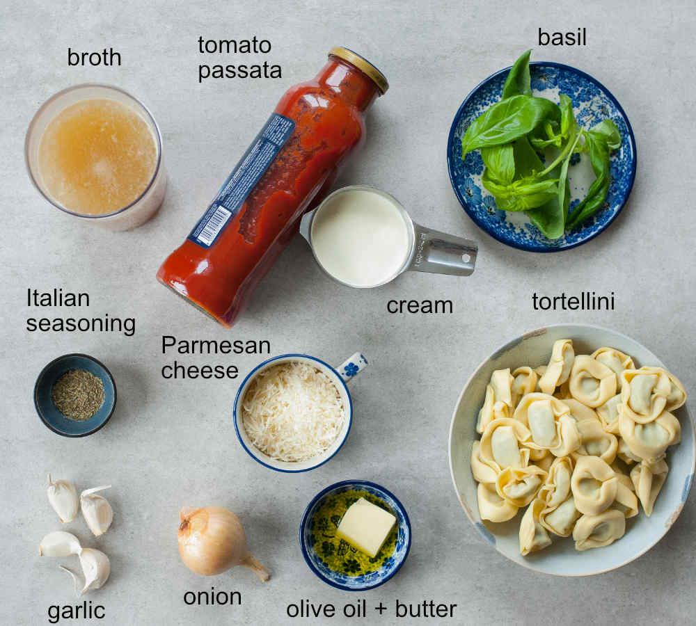 Labeled ingredients needed to prepare tomato tortellini soup.