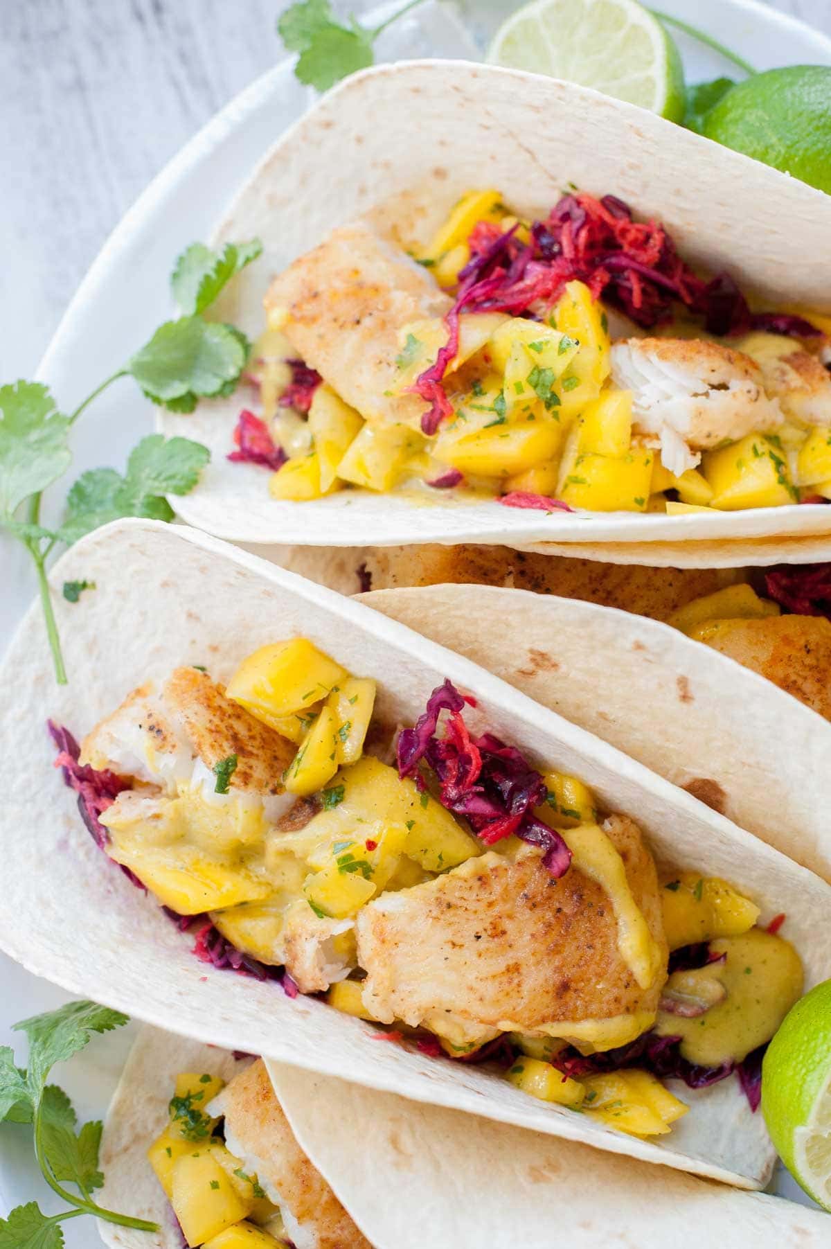 Fish tacos with mango salsa on a plate.