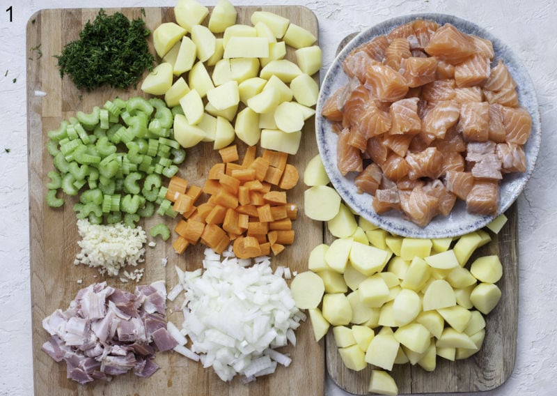 Chopped ingredients for salmon chowder on a chopping board.