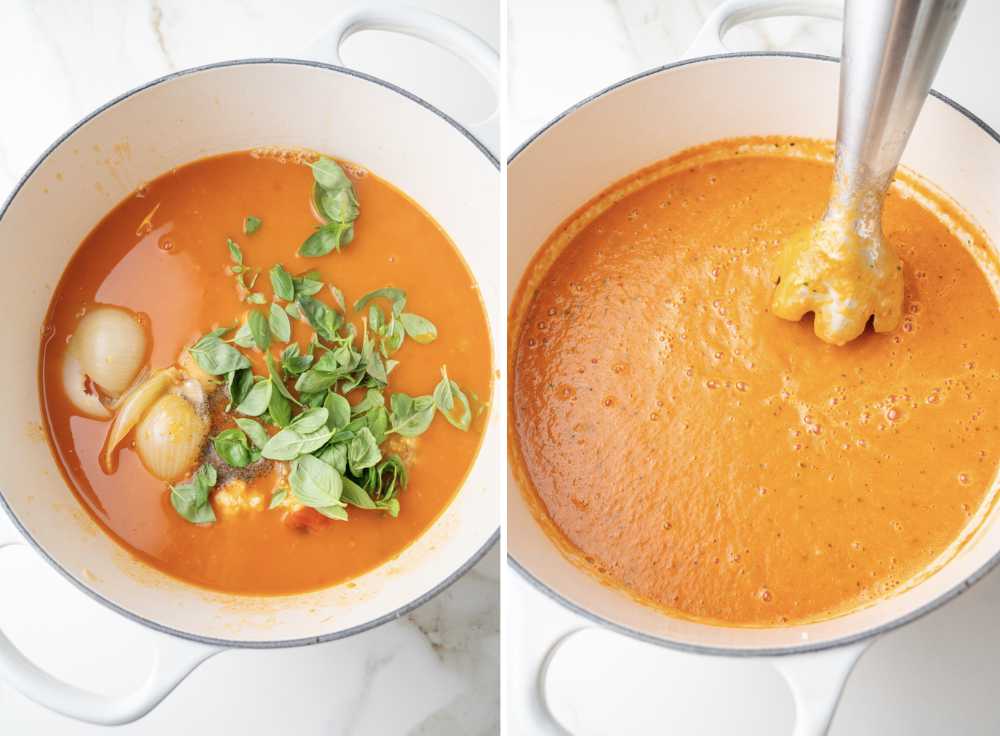 All ingredients for the soup and basil leaves in a pot. The soup is being blended with an immersion blender.