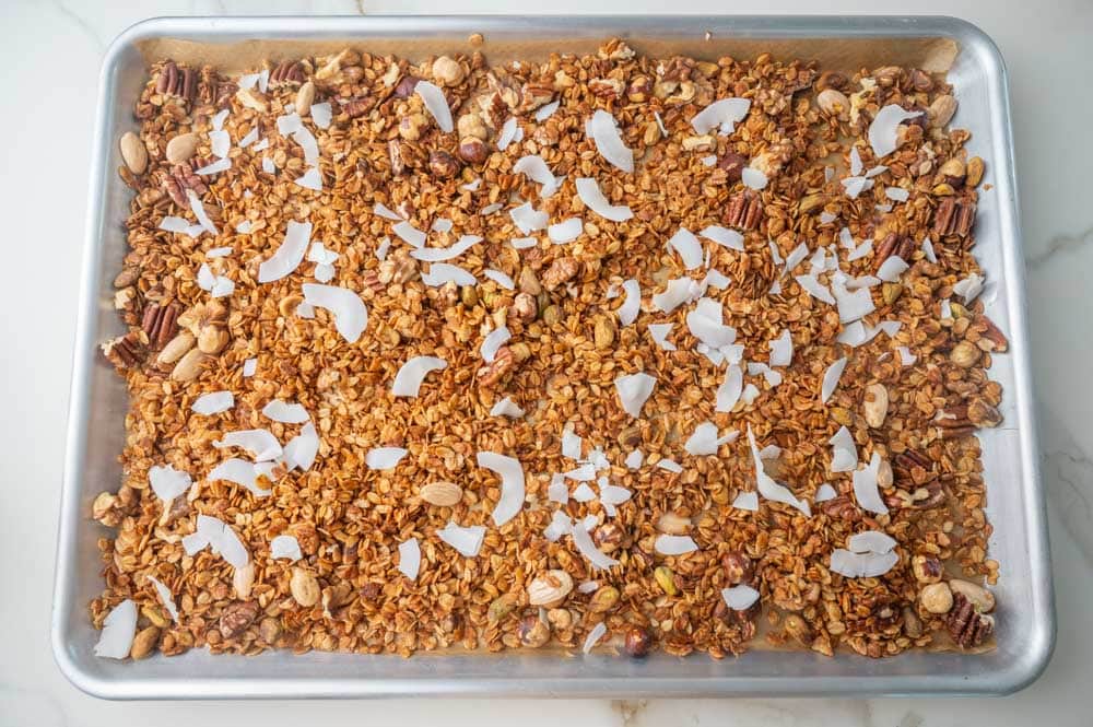 Baked oats with mixed nuts and coconut chips on a baking sheet.