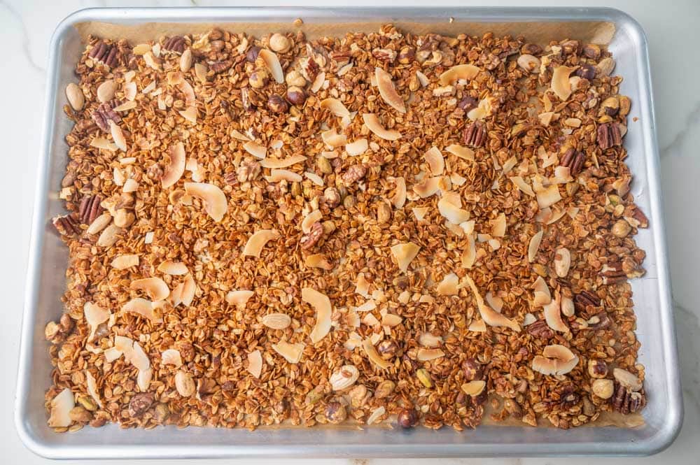 Baked oats with mixed nuts and coconut chips on a baking sheet.