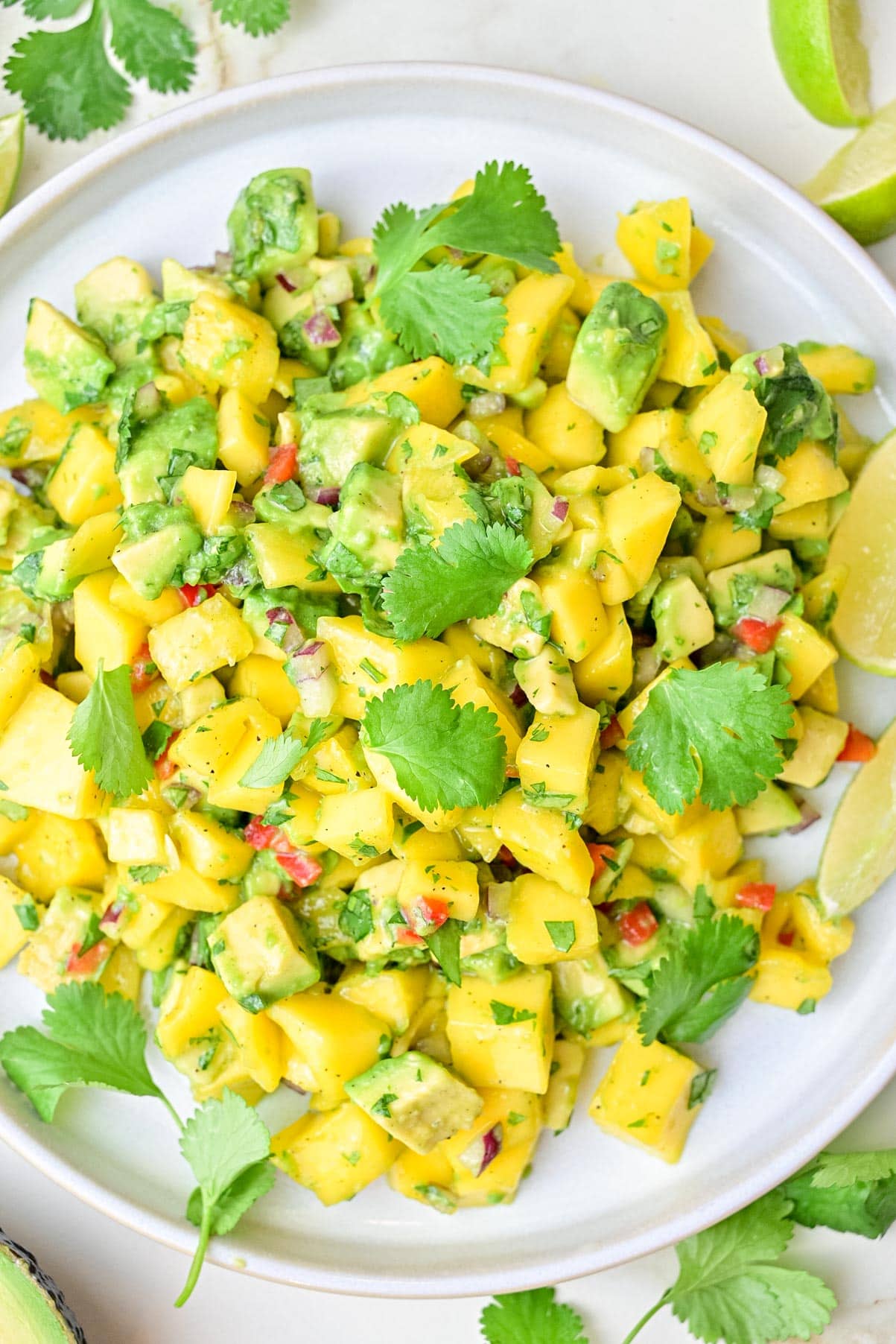 An overhead photo of mango avocado salsa on a white plate.