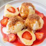 Polish strawberry dumplings knedle on a white plate.