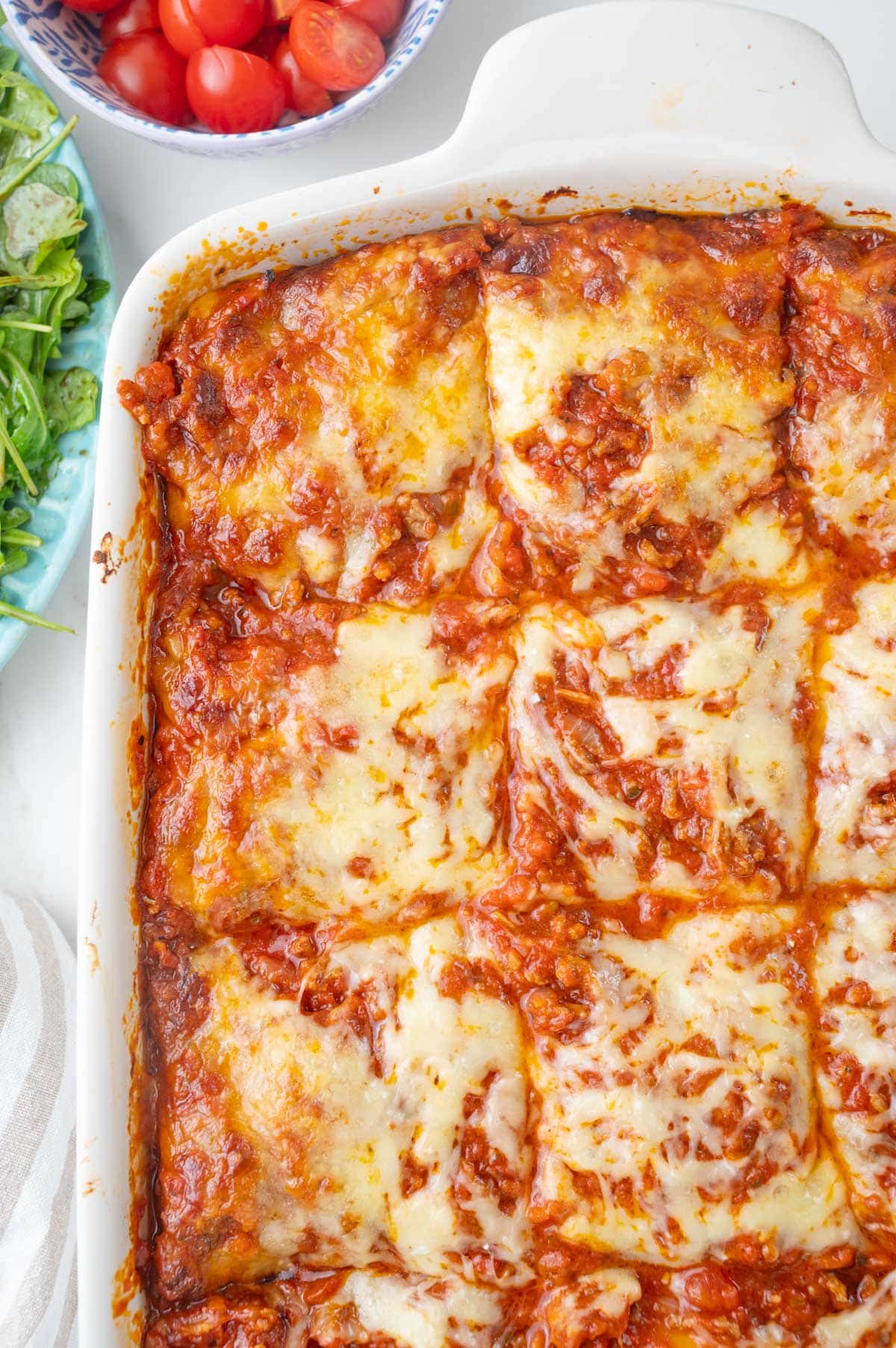 An overhead photo of ravioli lasagna in a casserole dish.