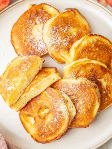 Apple ring pancakes on a beige plate.