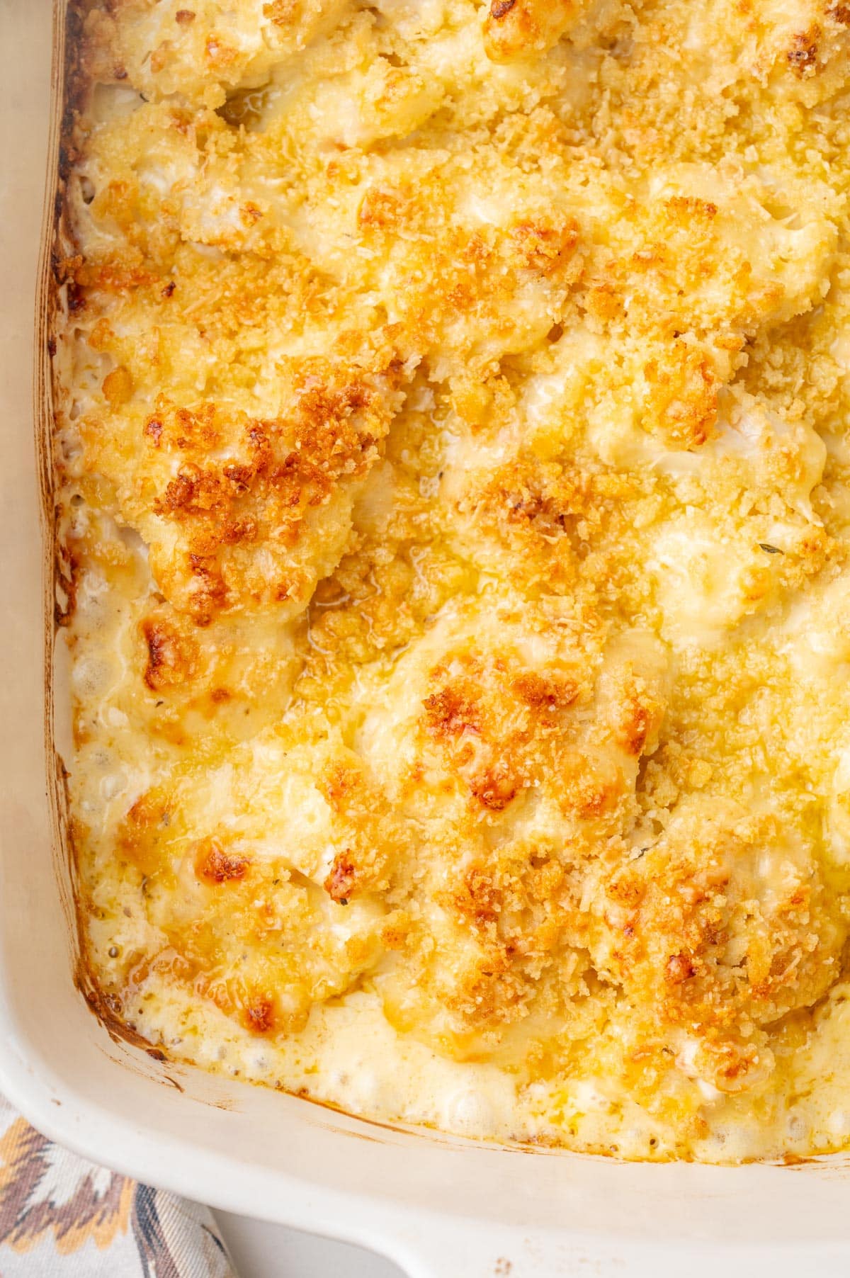 A close up photo of cauliflower gratin in a white baking dish