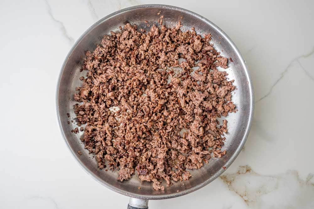 Browned ground beef in a pan.