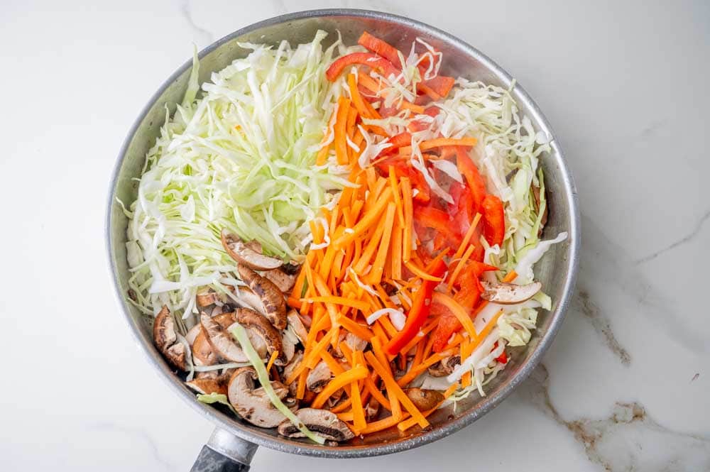 Chopped vegetables and mushrooms in a pan.