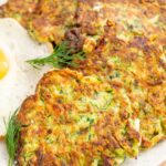 A close up photo of zucchini fritters on a white plate.