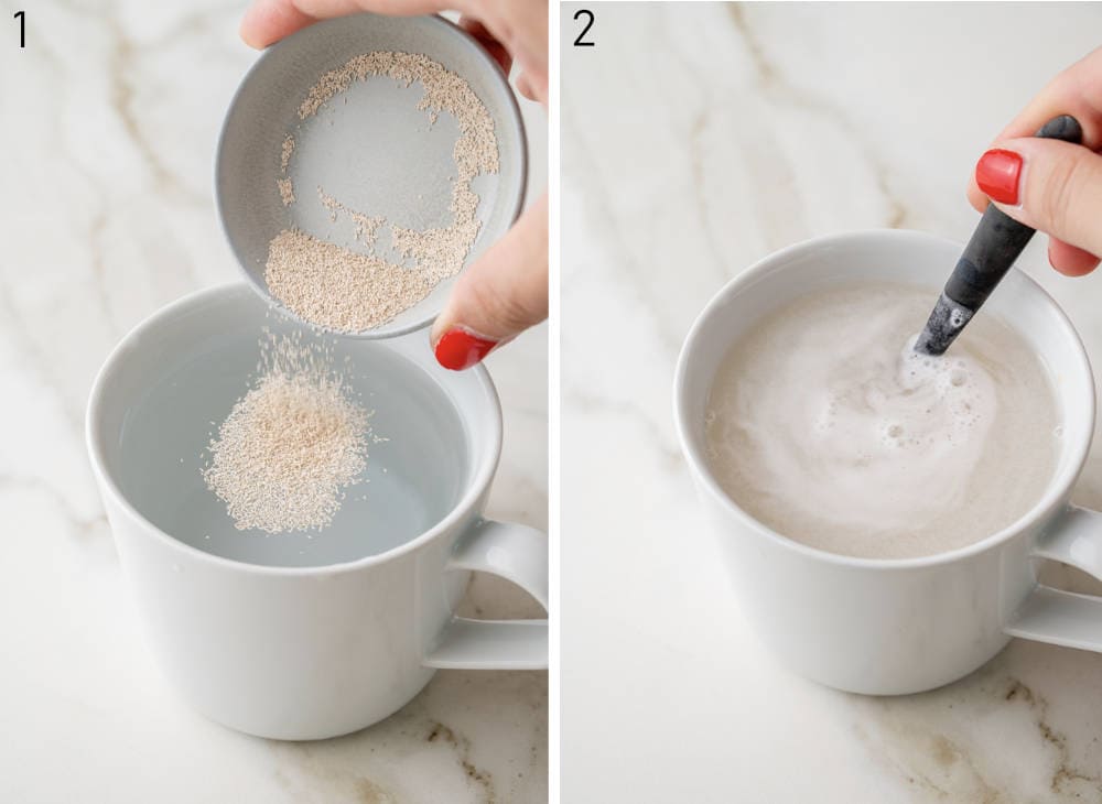 Yeast is added to water in a cup. Yeast water mixture is being stirred with a spoon.