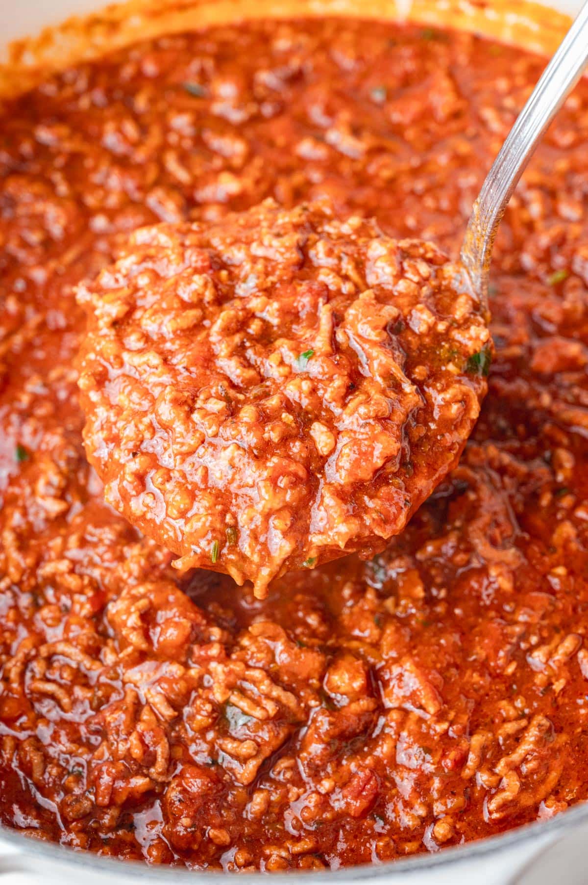 A close-up photo of spaghetti meat sauce on a ladle.