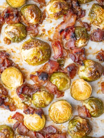 Roasted Brussels sprouts with bacon on a baking sheet.