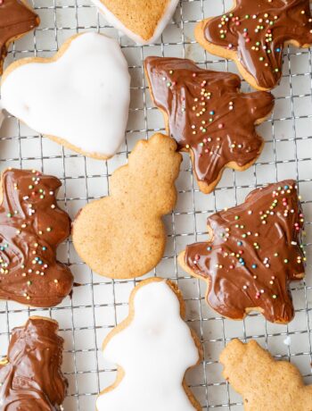 Polish pierniczki cookies decorated with icing and chocolate glaze on a cooling rack.