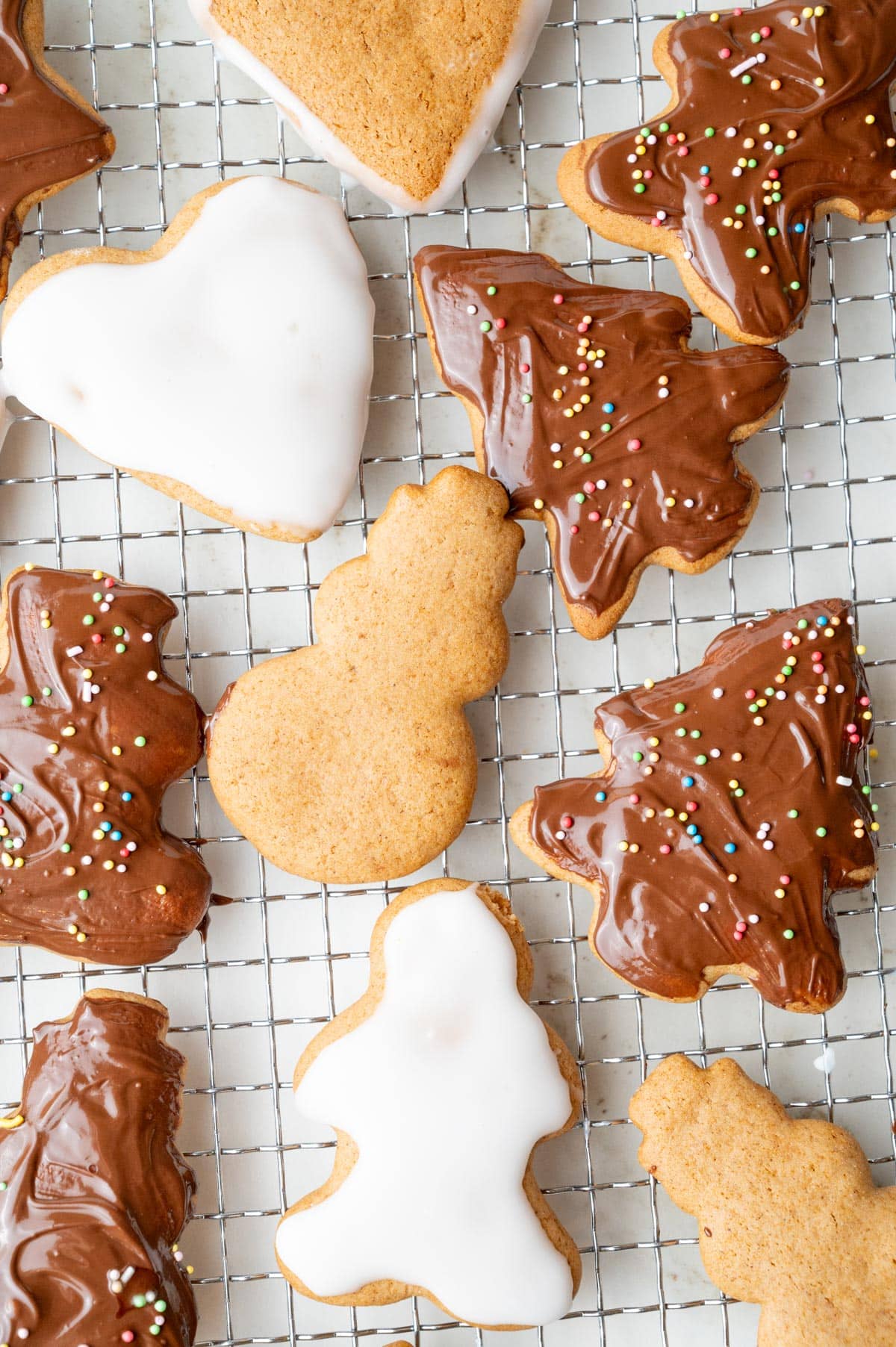 Polish pierniczki cookies decorated with icing and chocolate glaze on a cooling rack.